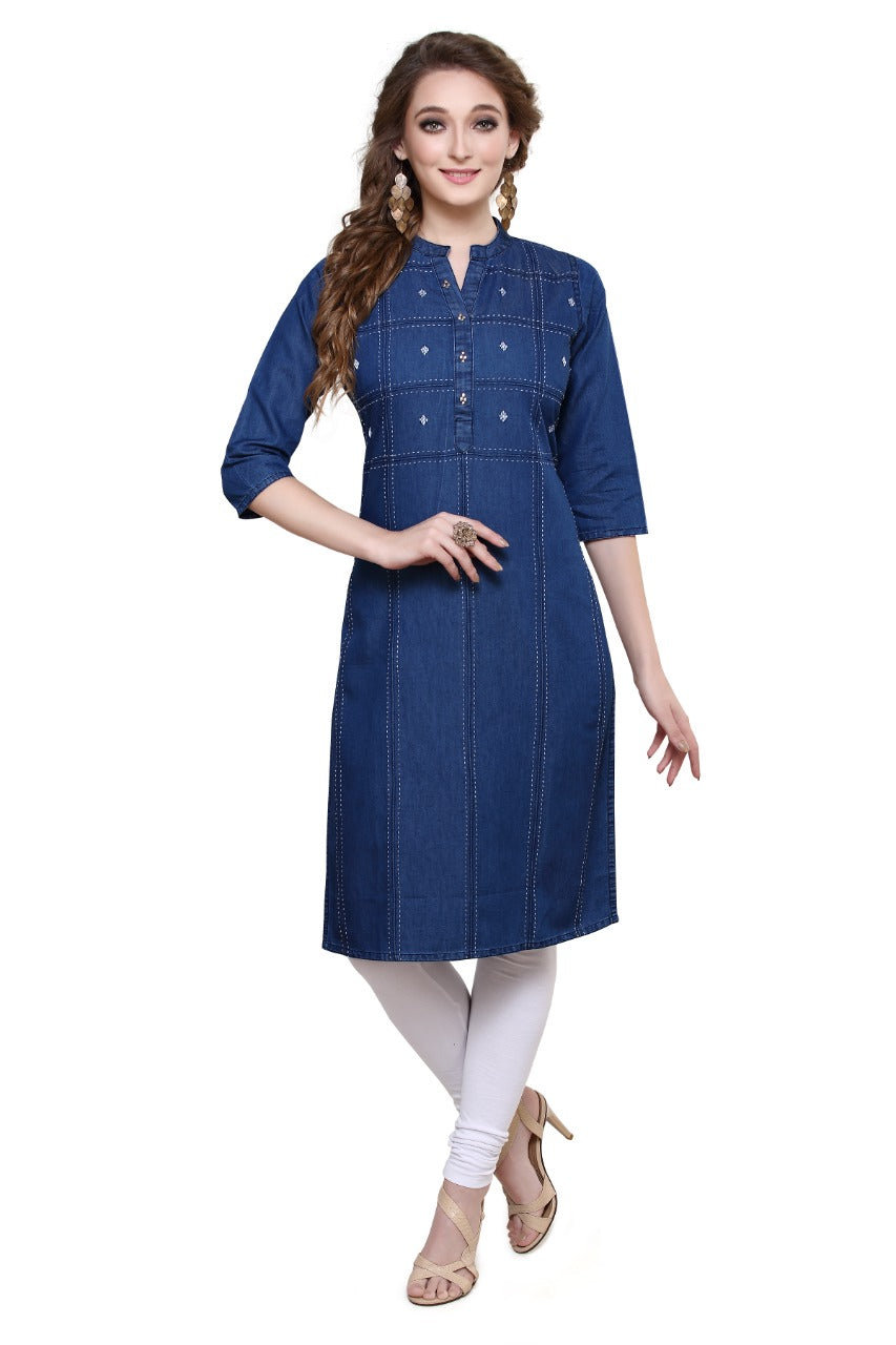 A woman modeling a blue denim-style straight kurta dress with three-quarter sleeves, a buttoned mandarin collar, and decorative stitching on the chest, paired with white leggings and beige heels against a plain white background.