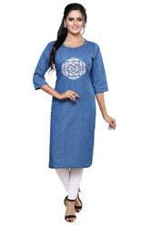 A woman modeling a blue denim-style straight kurta with three-quarter sleeves and a white printed mandala design on the chest, paired with white leggings and black sandals against a plain white background.
