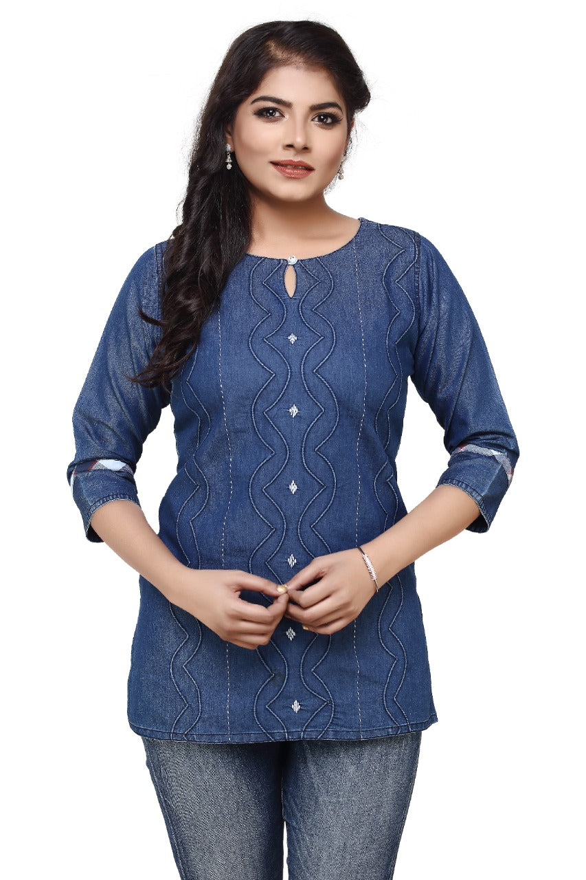 A woman modeling a blue denim-style kurta with vertical wavy embroidery and silver button accents, paired with blue jeans, against a plain white background.