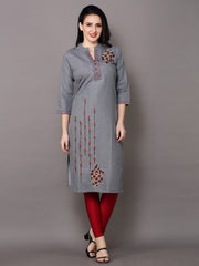 A woman modeling a gray three-quarter sleeve kurta with red and gold embroidered details, paired with red leggings and black sandals, against a solid gray studio background.