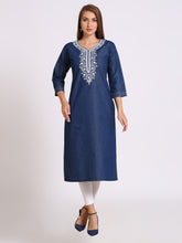 A woman modeling a navy blue cotton kurta with white embroidery around the neckline, paired with white leggings and navy blue heels, against a light gray studio background.