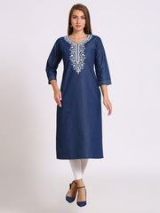 A woman modeling a navy blue cotton kurta with white embroidery around the neckline, paired with white leggings and navy blue heels, against a light gray studio background.
