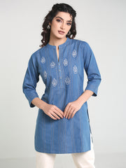Woman wearing a blue embroidered kurta against a white background