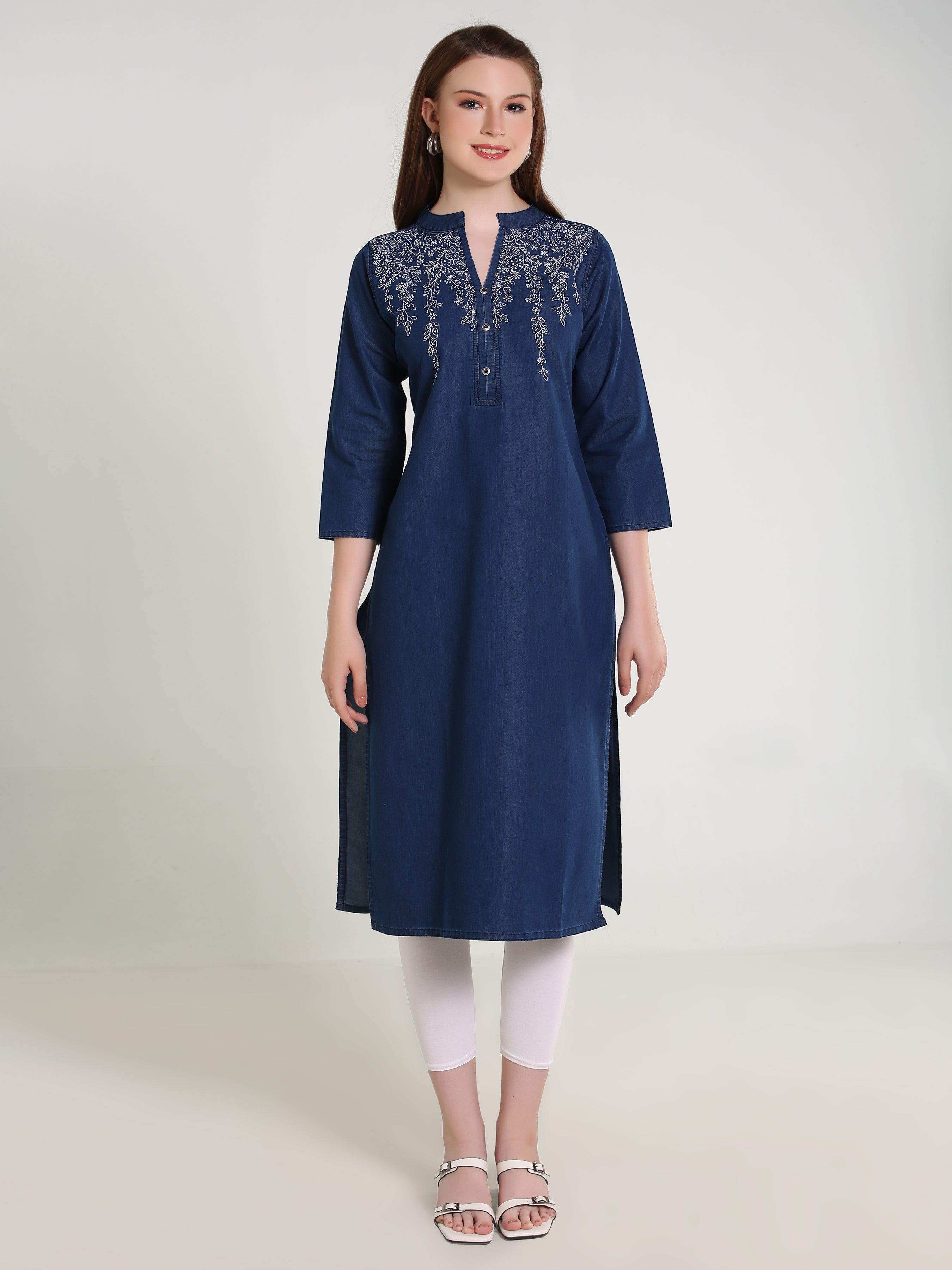 Woman wearing a navy blue kurta with white embroidery on a light gray background